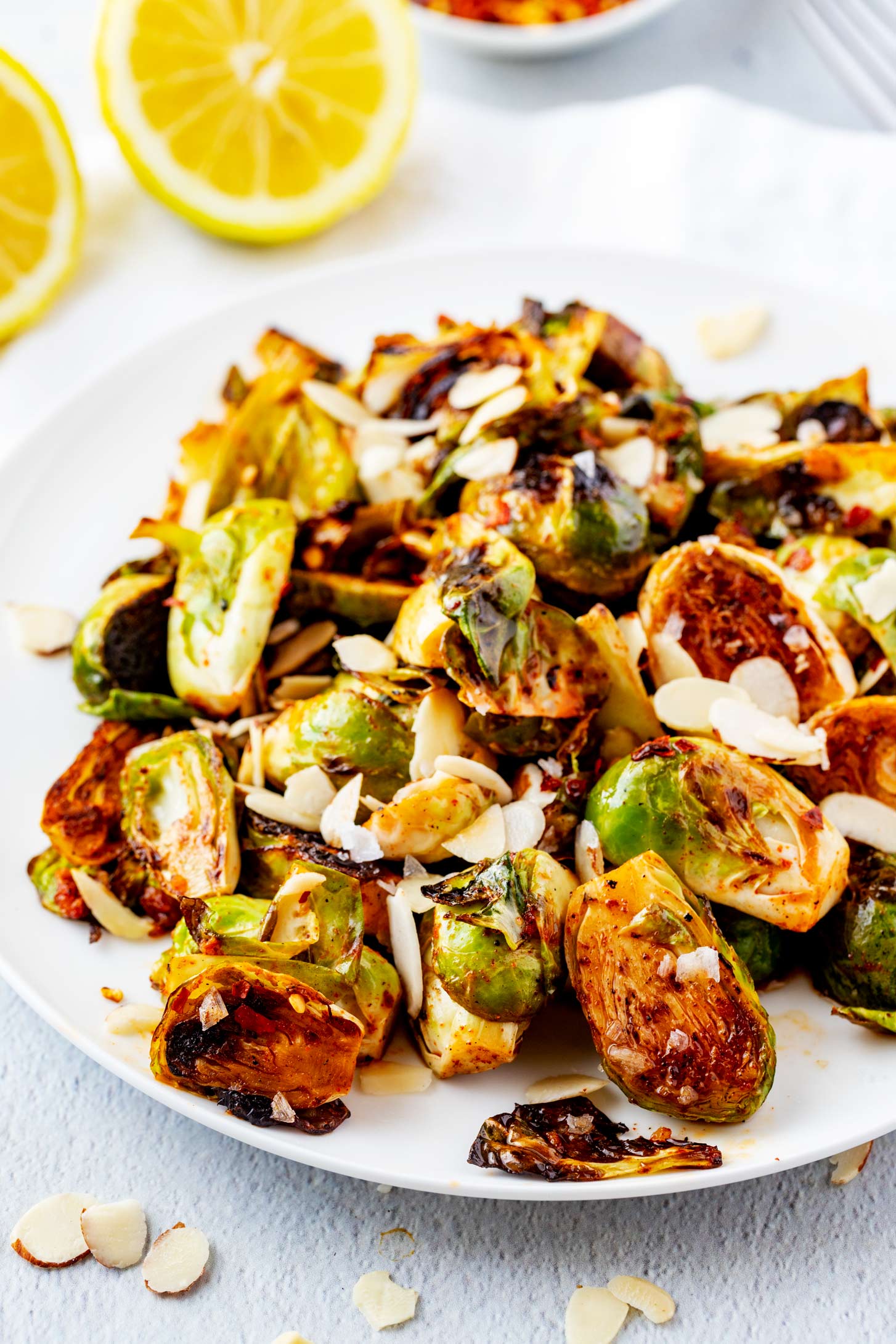 Photo of a white plate of Blackstone Brussels sprouts garnished with almonds.