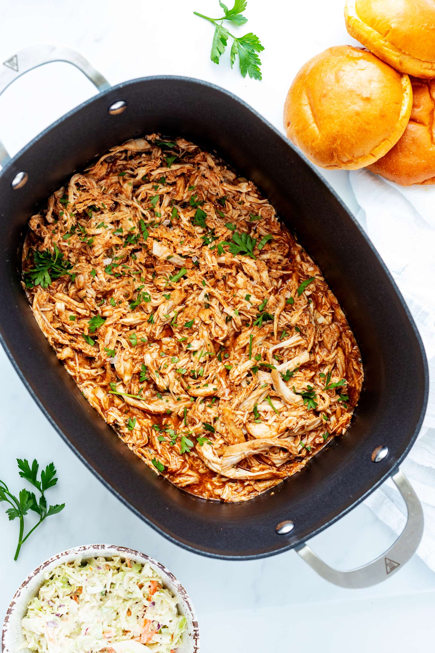Overhead photo of a slow cooker with shredded BBQ chicken in it.