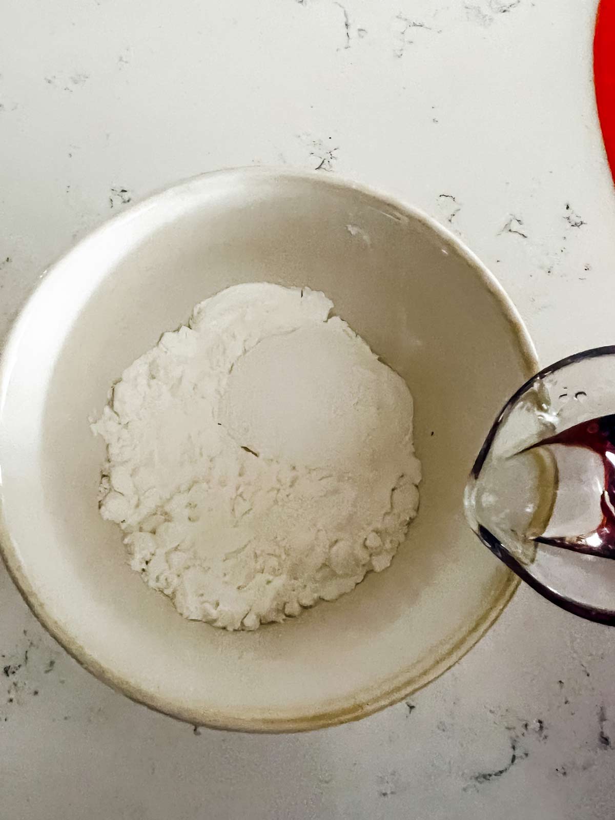 Water and cornstarch being mixed together to form a slurry.