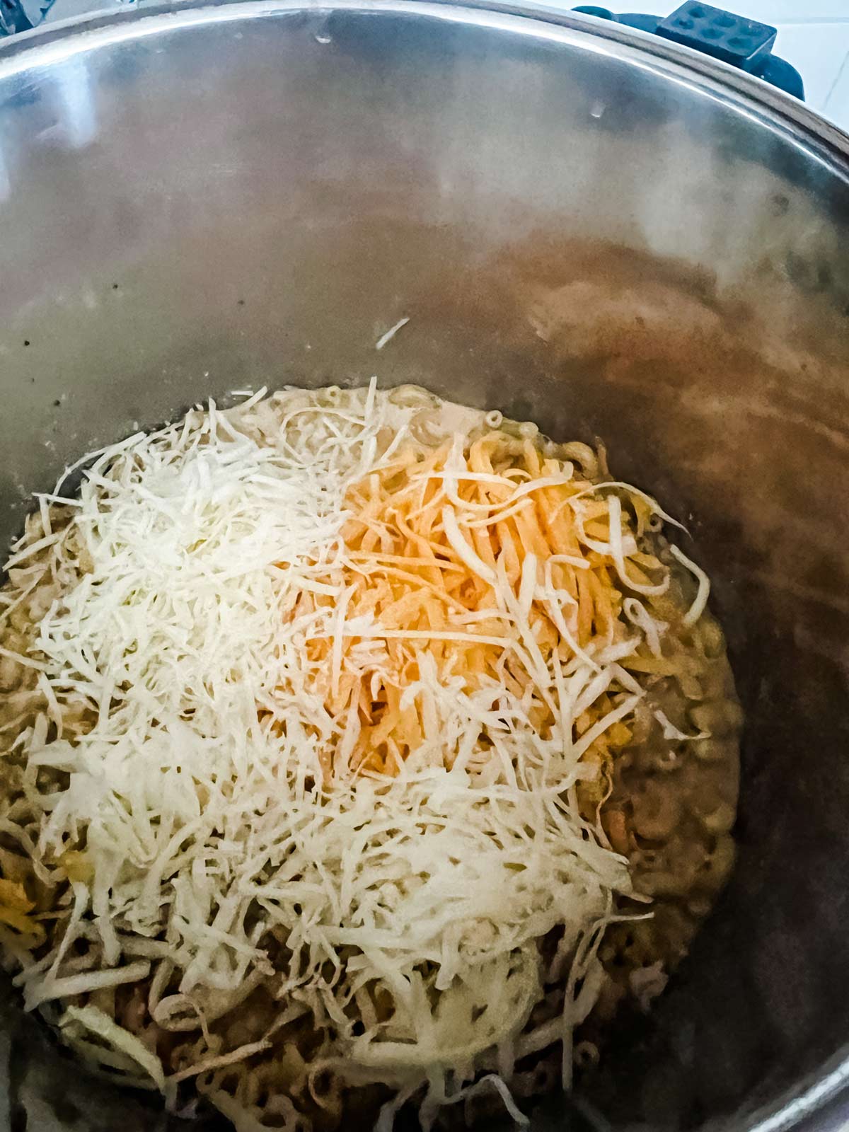 Cheese on top of cooked pasta and milk in an Instant pot.