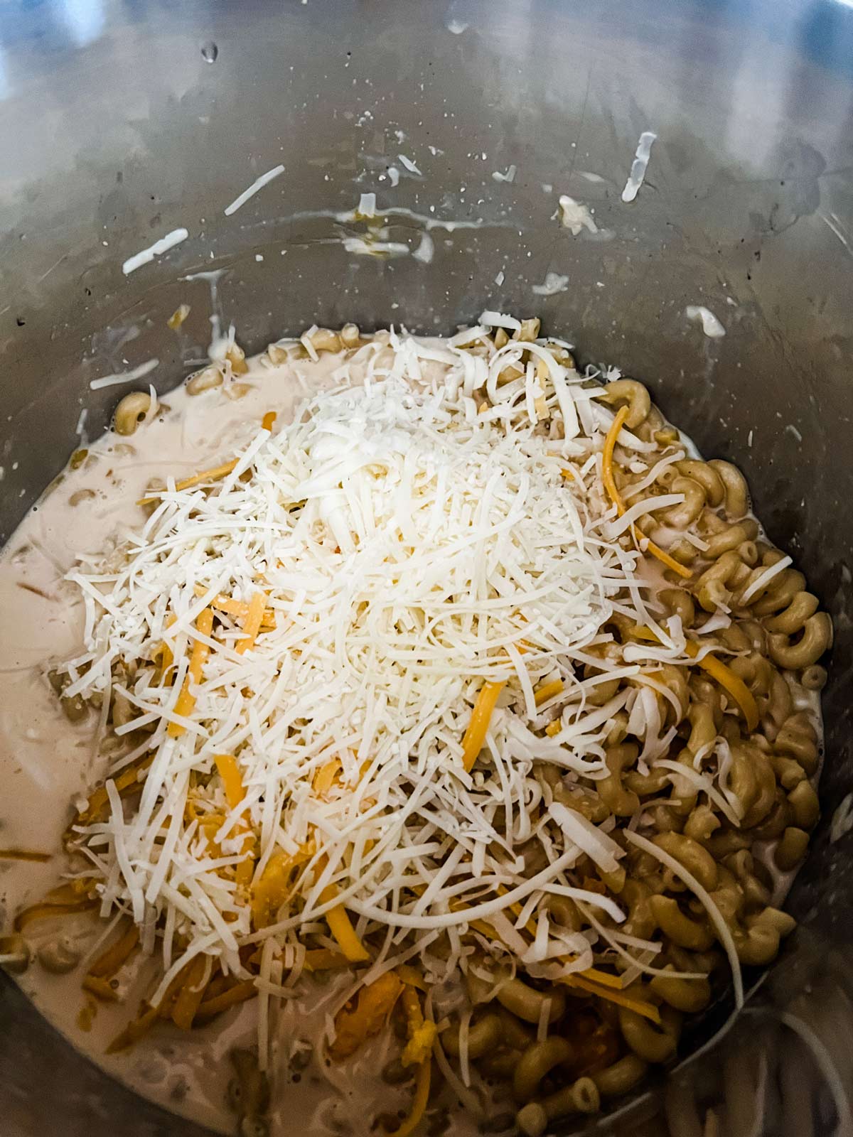 More cheese being added to Instant Pot Mac and cheese.
