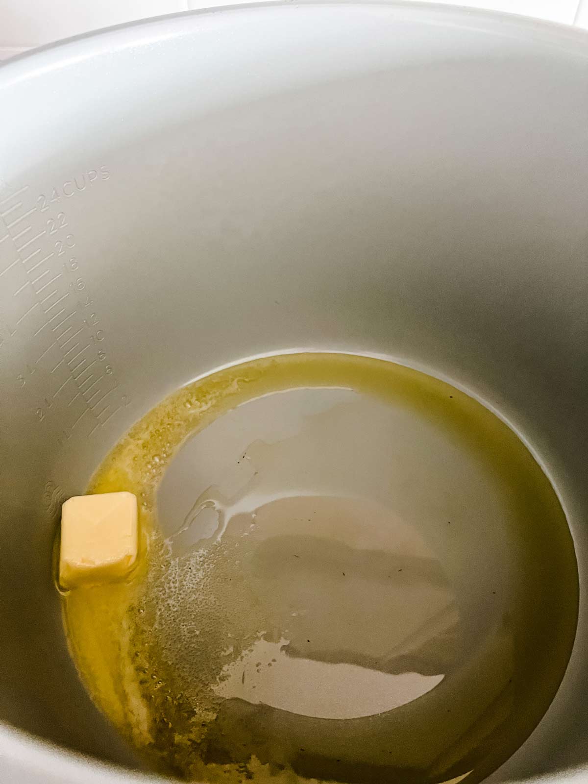 Butter and oil in the inner pot of a Ninja Foodi.