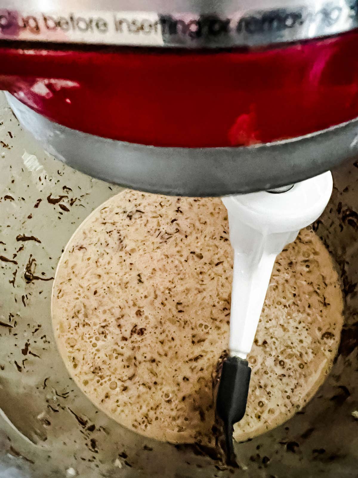 Eggs, milk, butter, Nutella, and vanilla being mixed in the bowl of a stand mixer.