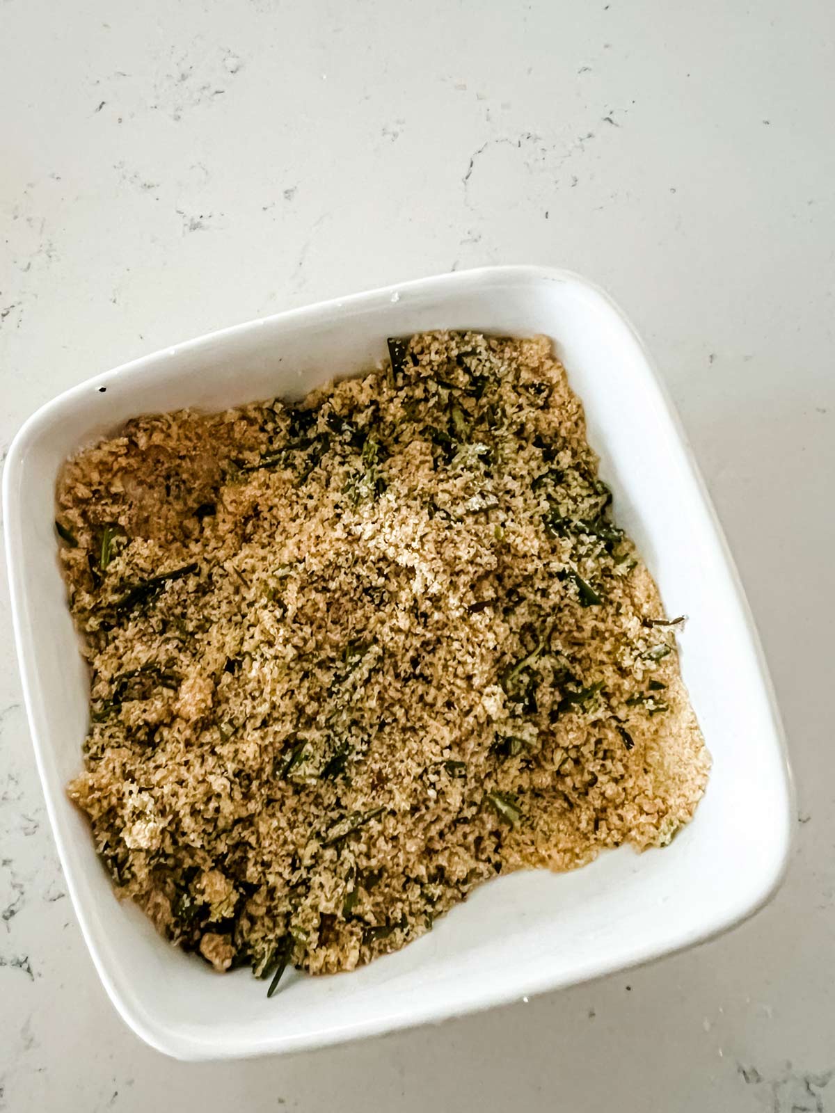 Rosemary, brown sugar, garlic powder, salt, and pepper mixed together in a small dish.