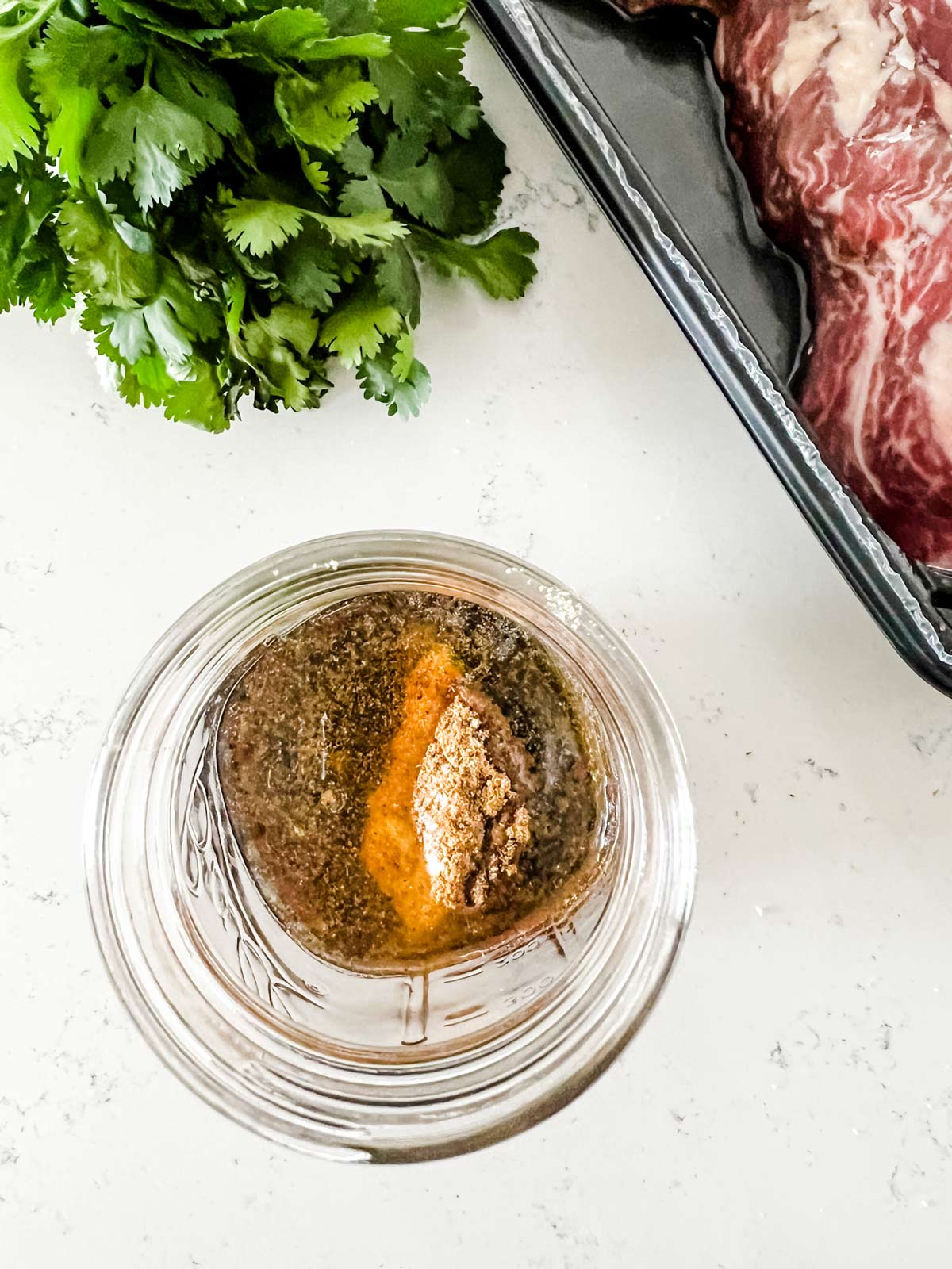 Steak taco marinade ingredients in a glass jar.