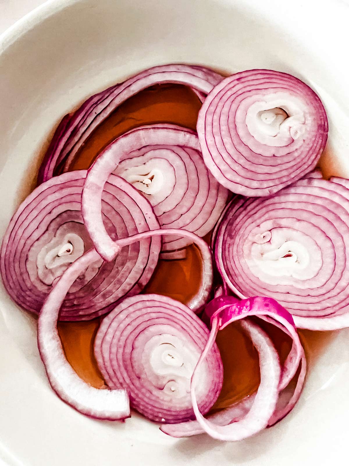 Sliced red onion marinating in red wine vinegar.