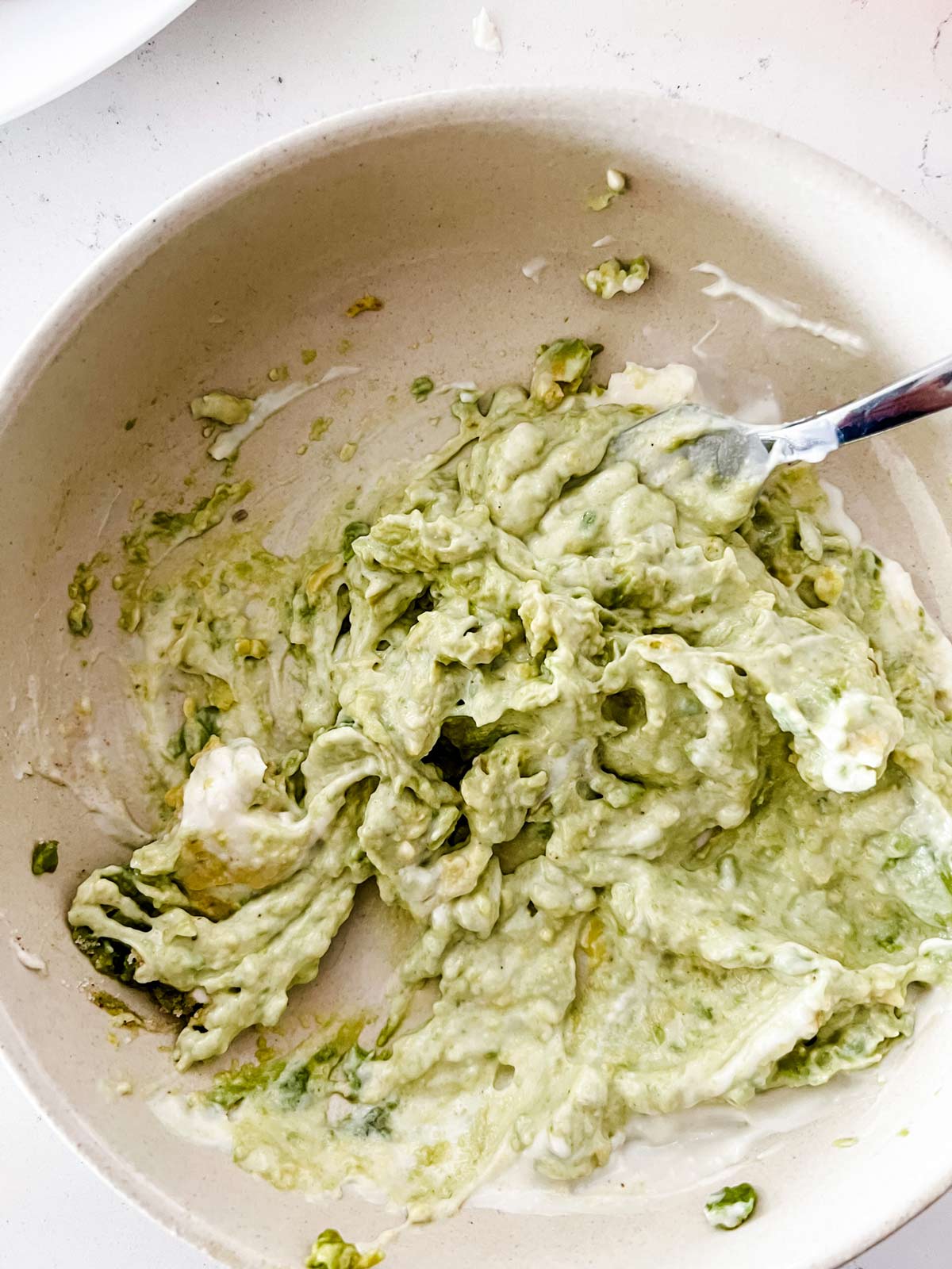 An avocado mayo mixture in a shallow bowl.