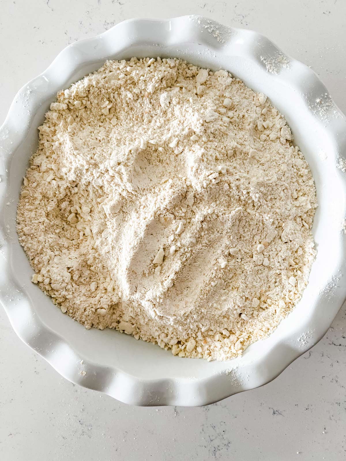 Finely crushed saltine crackers and flour in a pie plate.