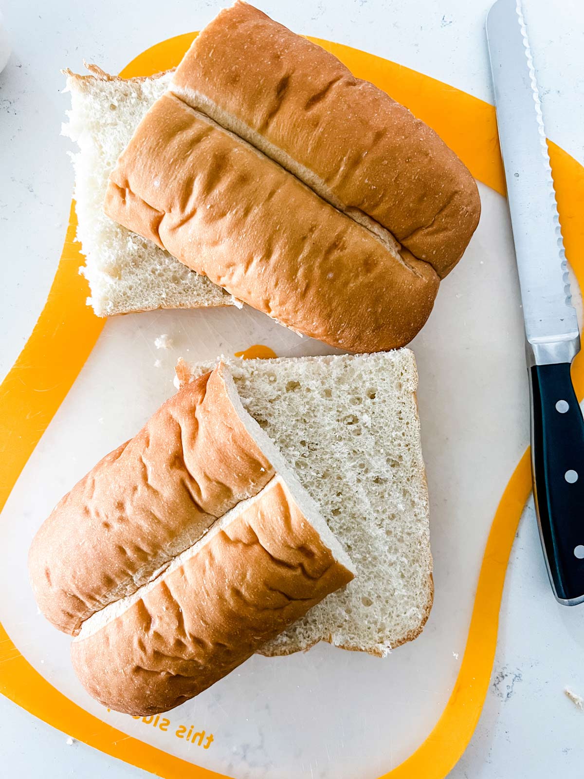 A loaf of Italian bread sliced in half lengthwise and through the middle.