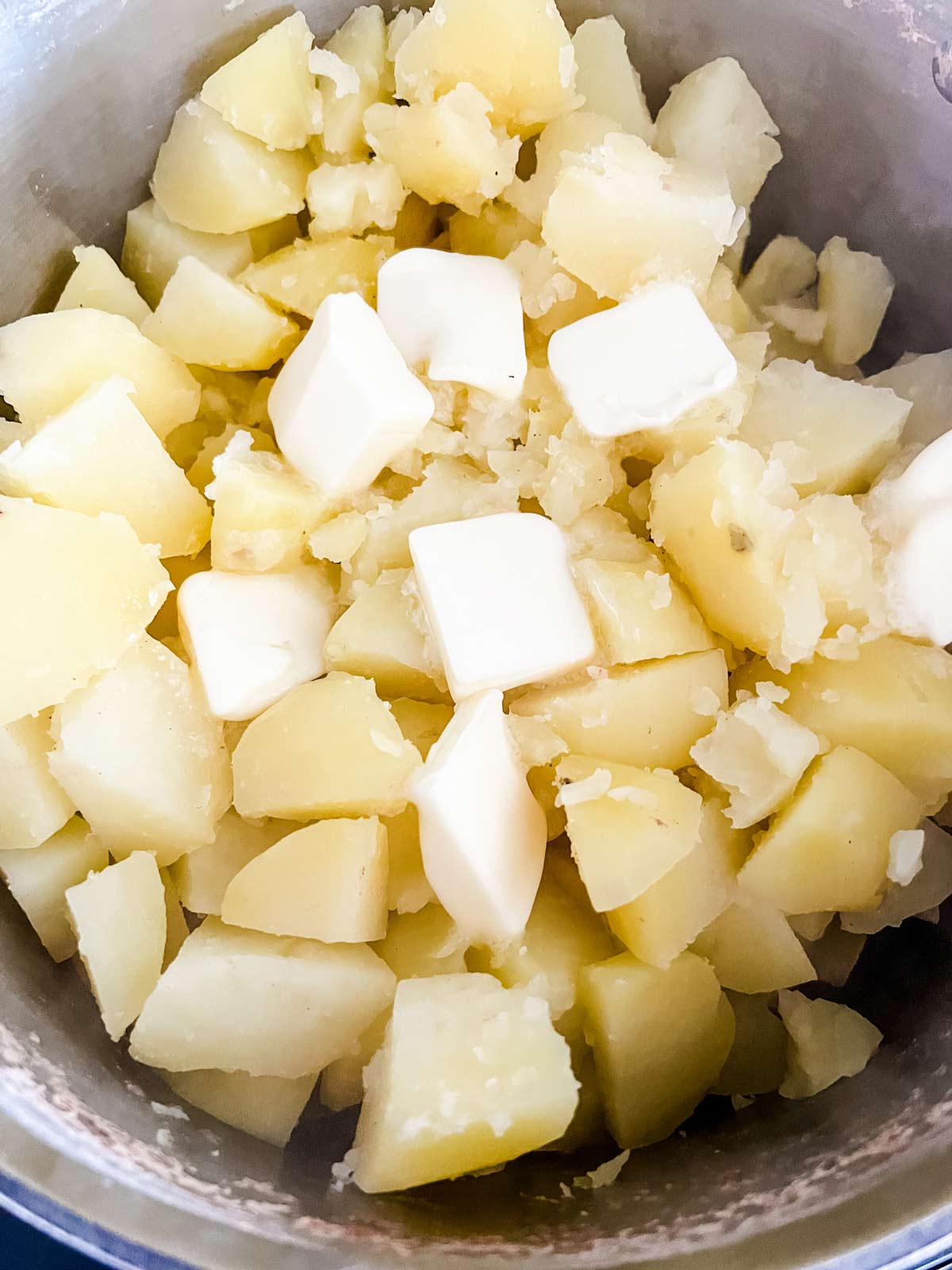 Cooked diced potatoes with butter on top.