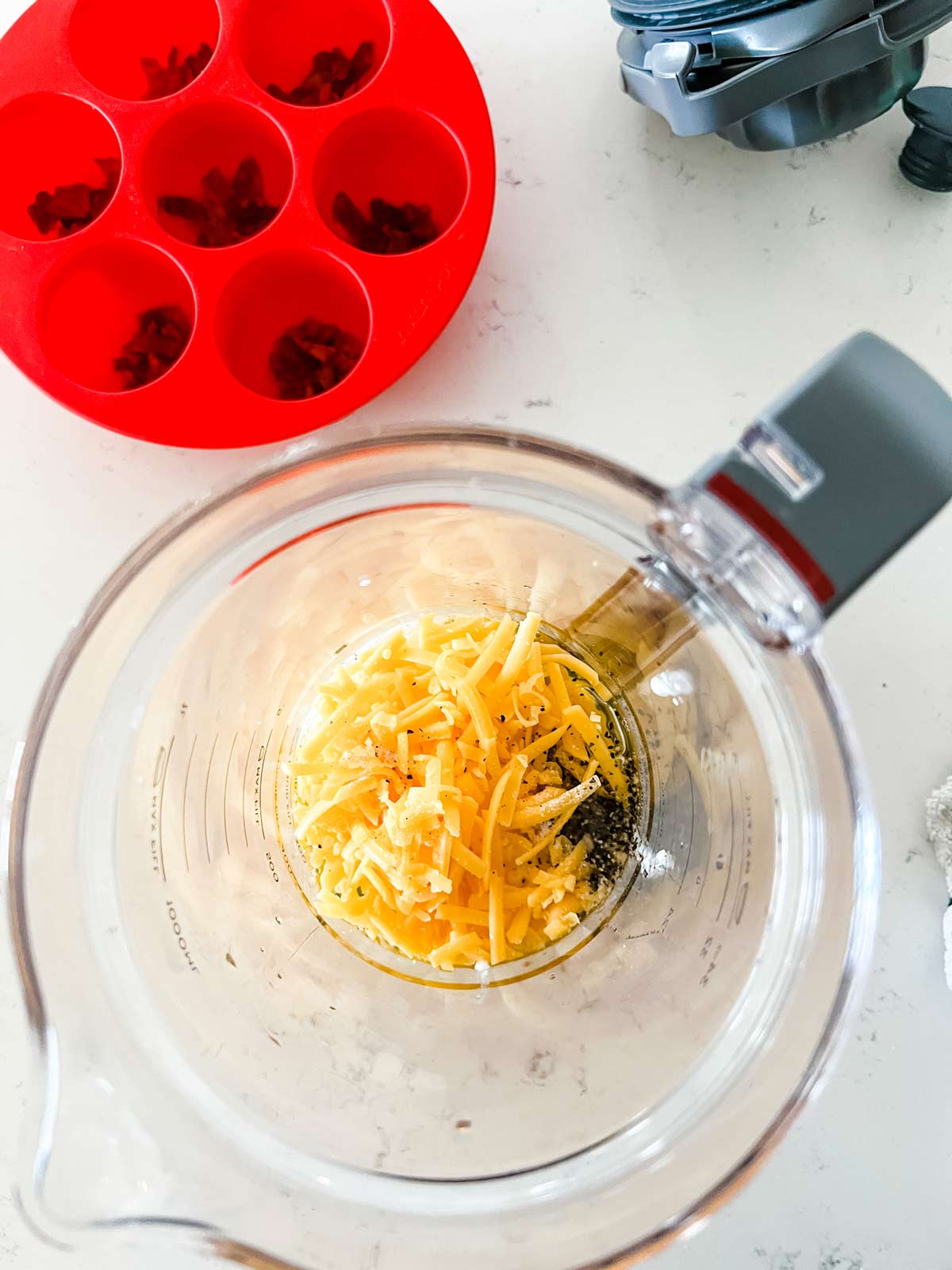A blender with eggs, cottage cheese, shredded cheese and seasonings.