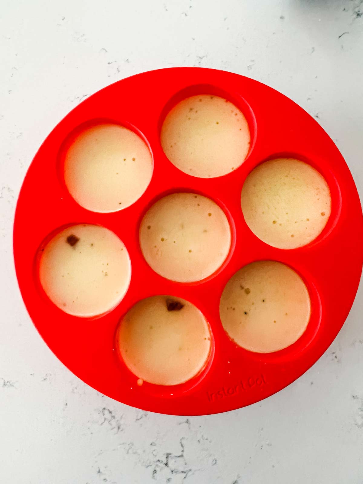 Photo of egg bites ready to cook in a silicone mold.