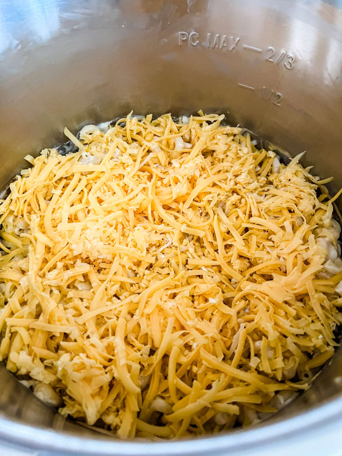 Cheese on top of Instant Pot mac and cheese ready to melt.