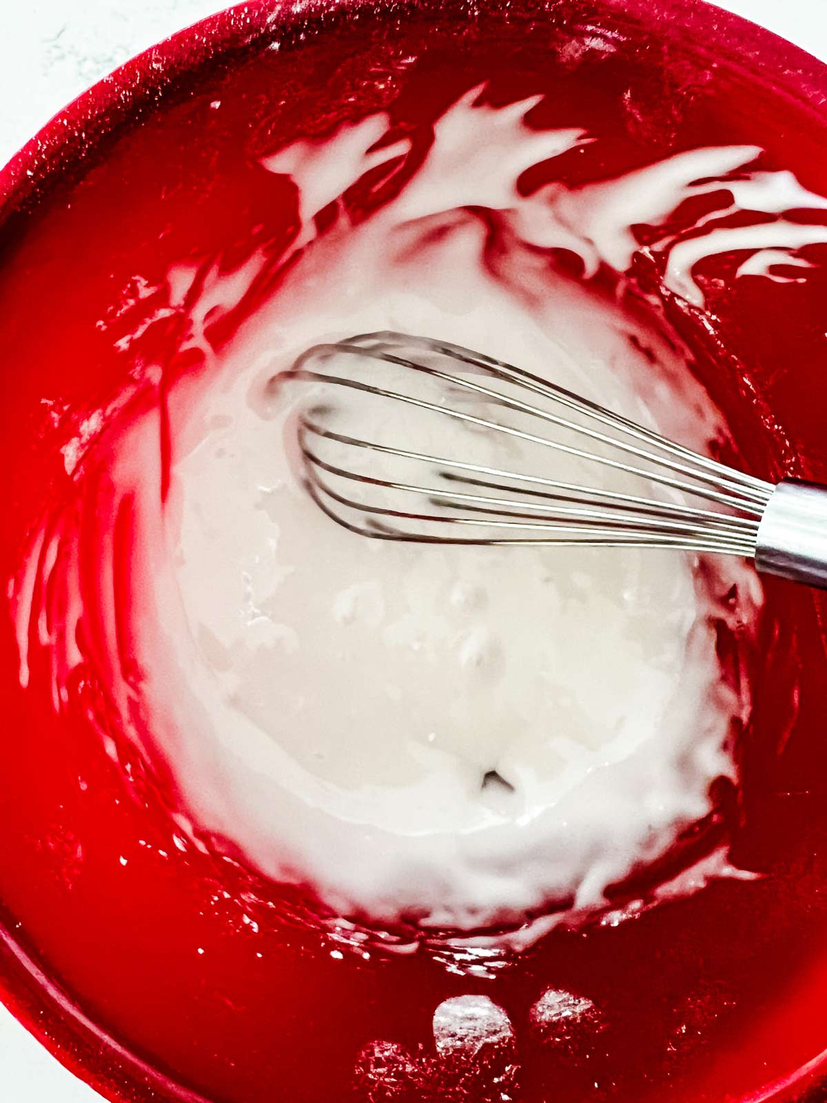 Powdered sugar and lemon juice being blended in a bowl to make a glaze.