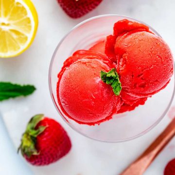 Square side photo of Ninja Creami Strawberry sorbet in a glass dish garnished with mint.