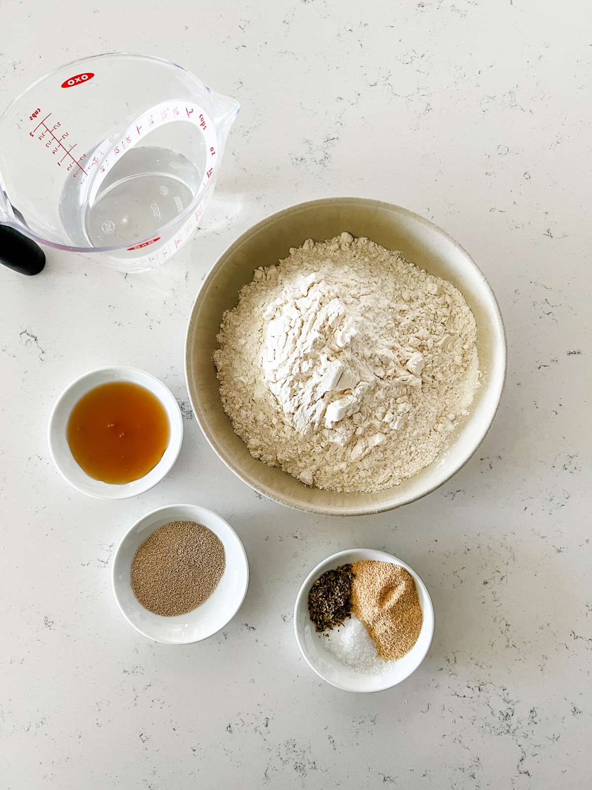 Overhead photo of flour, honey, water, yeast, sugar, and seasonings.