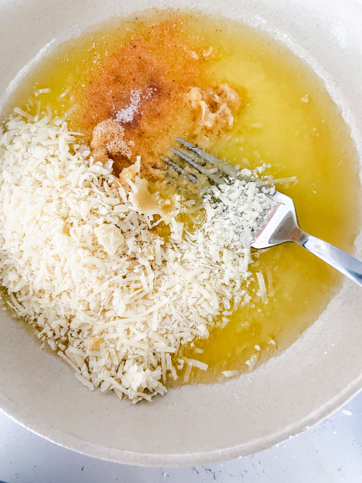 Oil, seasonings, and parmesan in a small bowl.