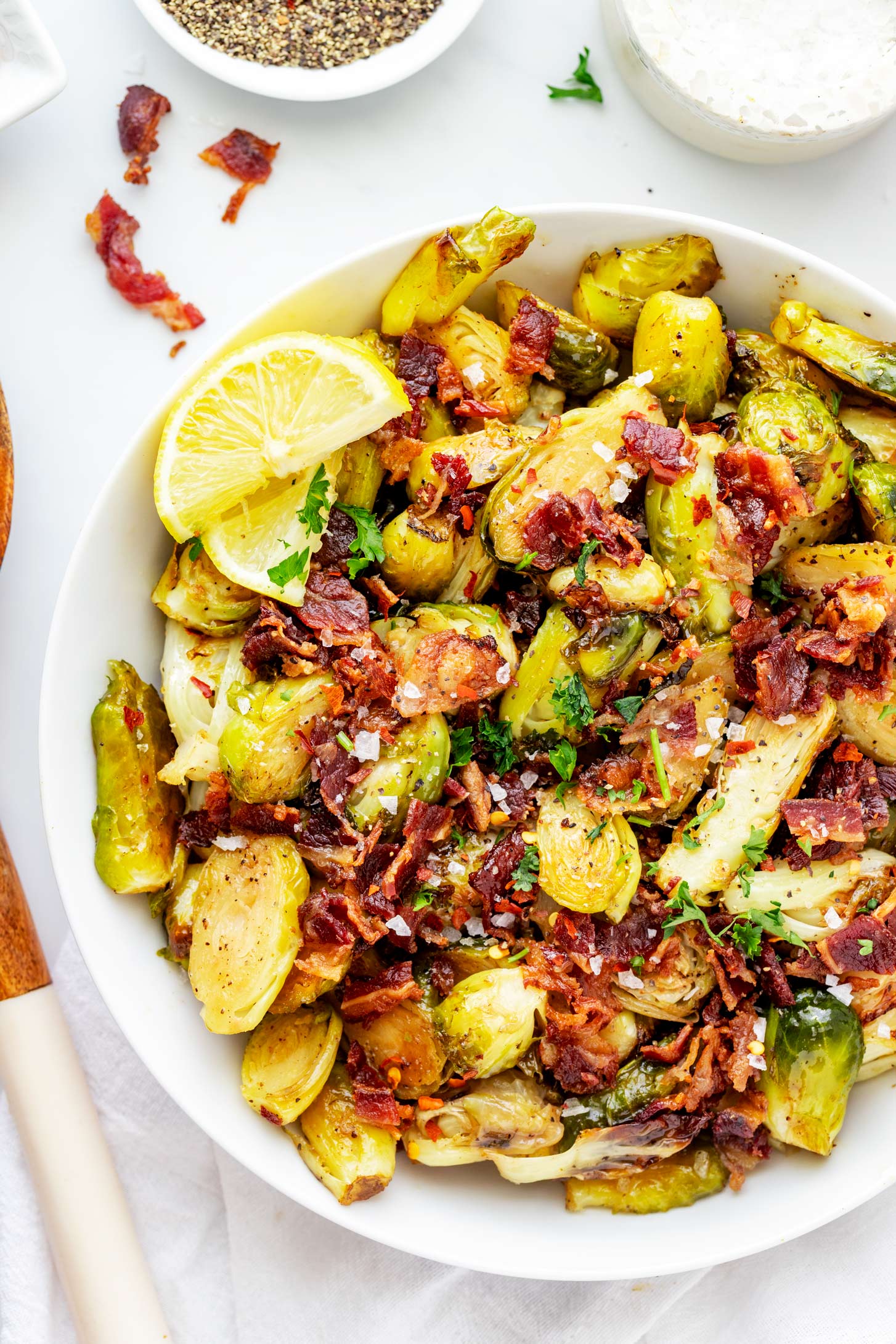 Overhead photo of a shallow white bowl of brussels sprouts with bacon.