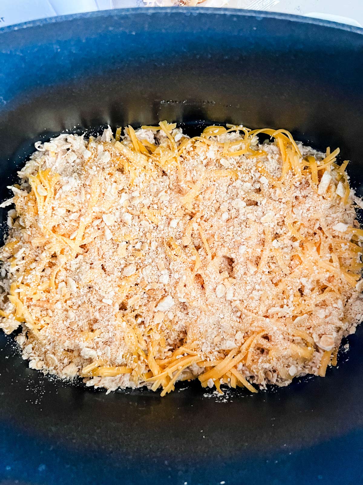 Crockpot chicken and noodles covered with cheese.