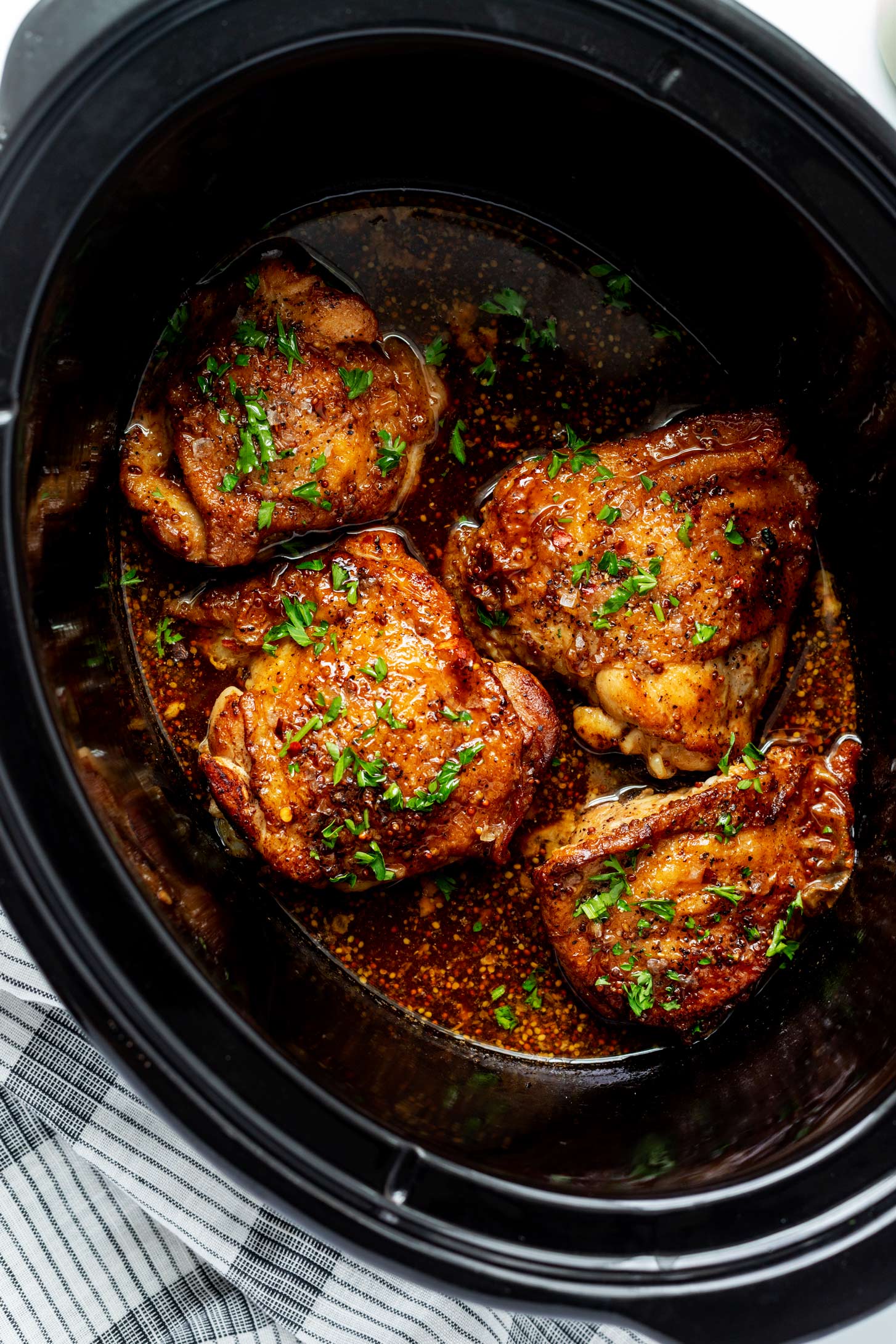 Photo of cooked chicken thighs in a slow cooker.