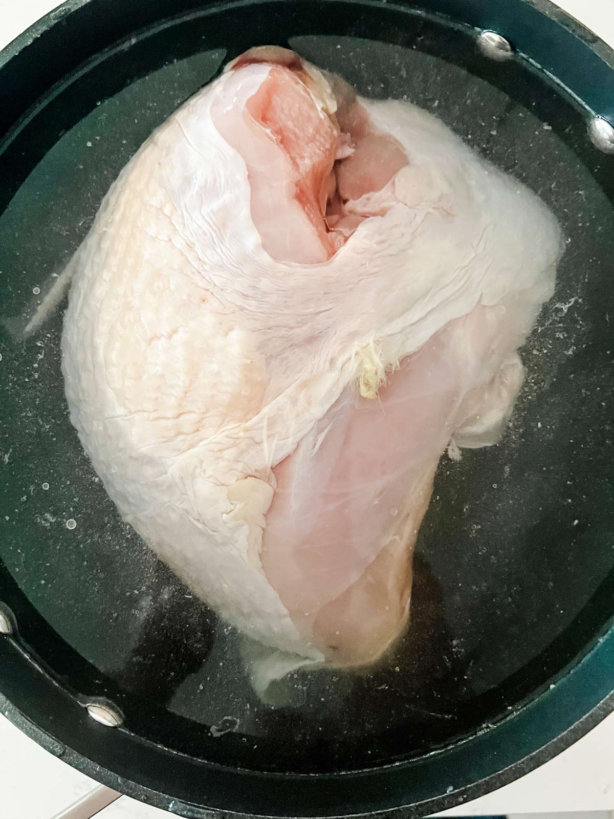 A turkey breast brining in salt water.