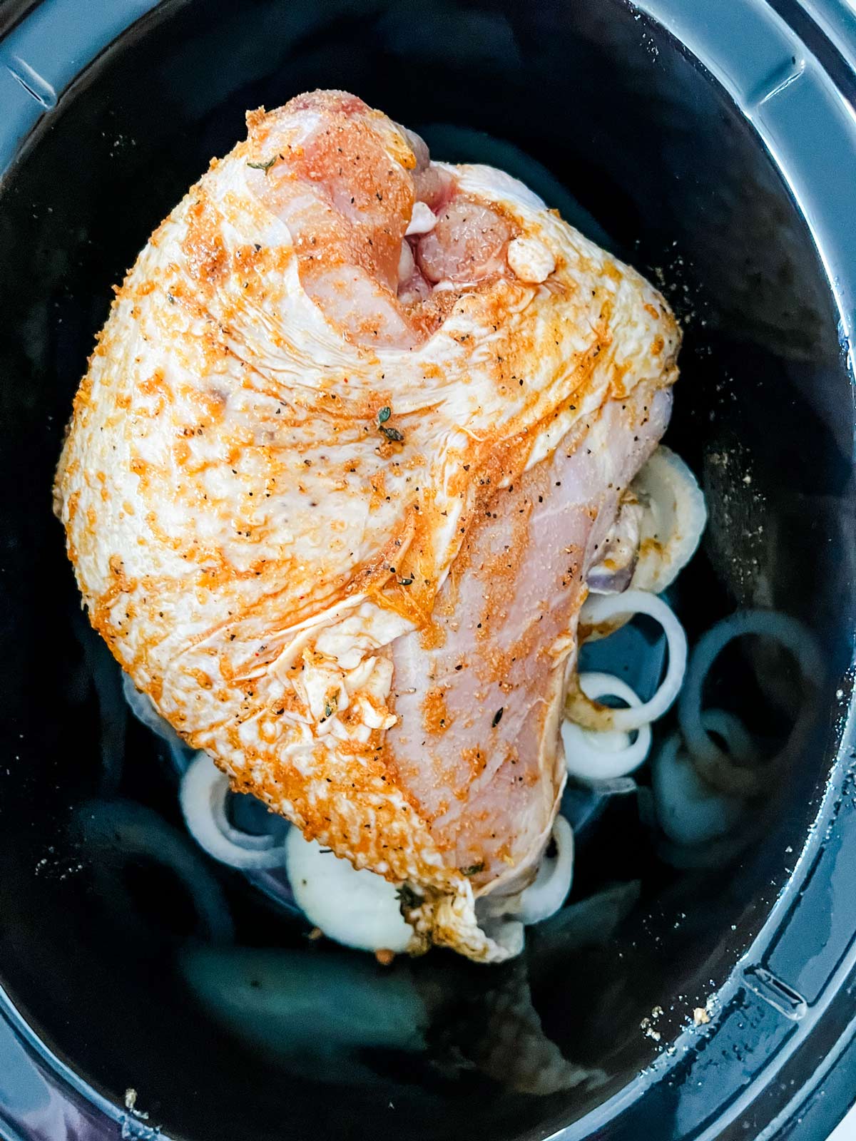 Seasoned turkey breast in a slow cooker.