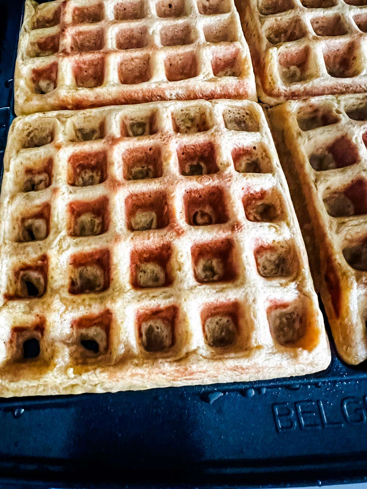 Cooked pumpkin waffles ready to be removed from a waffle iron.