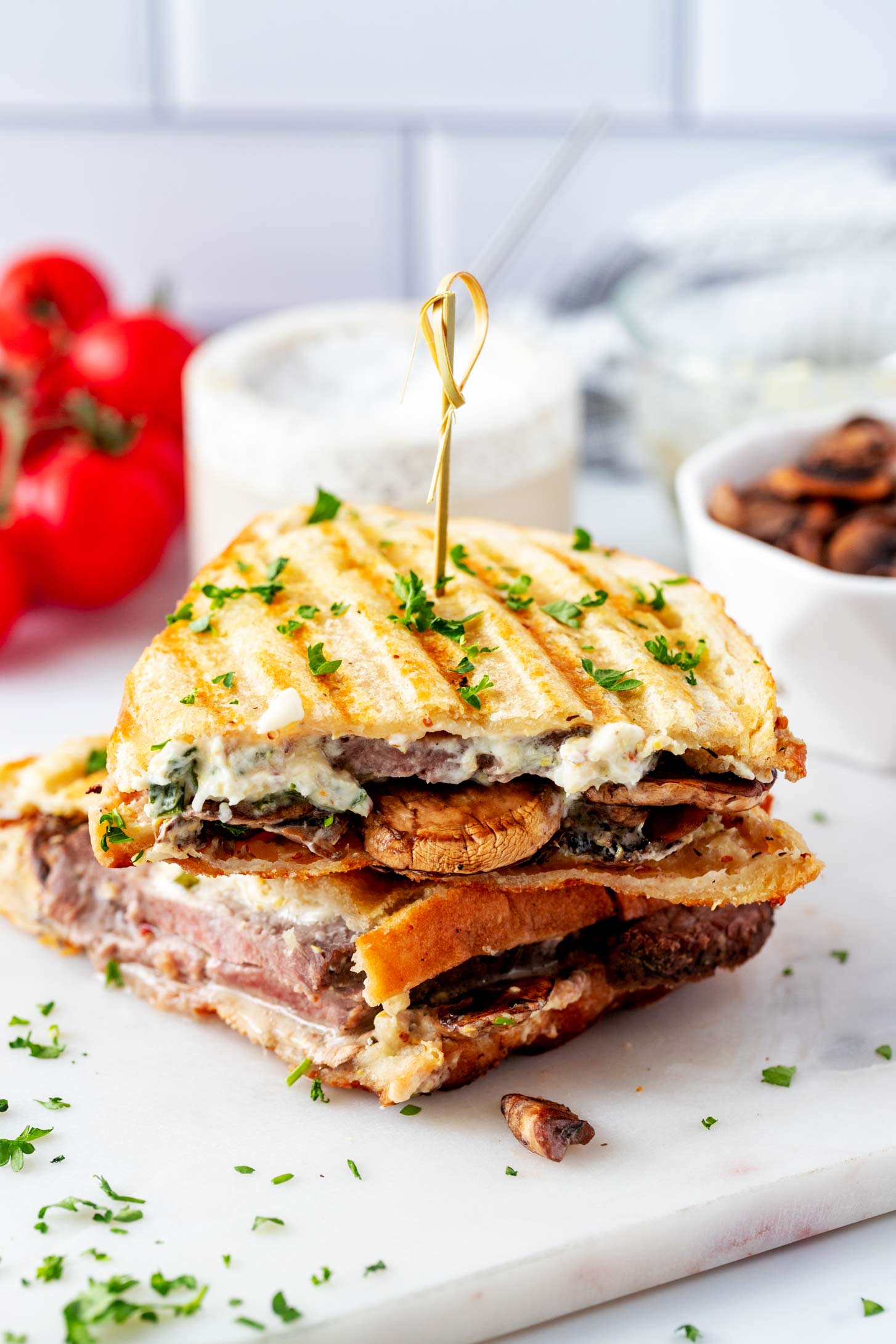 Side photo of a roast beef panini garnished with parsley.