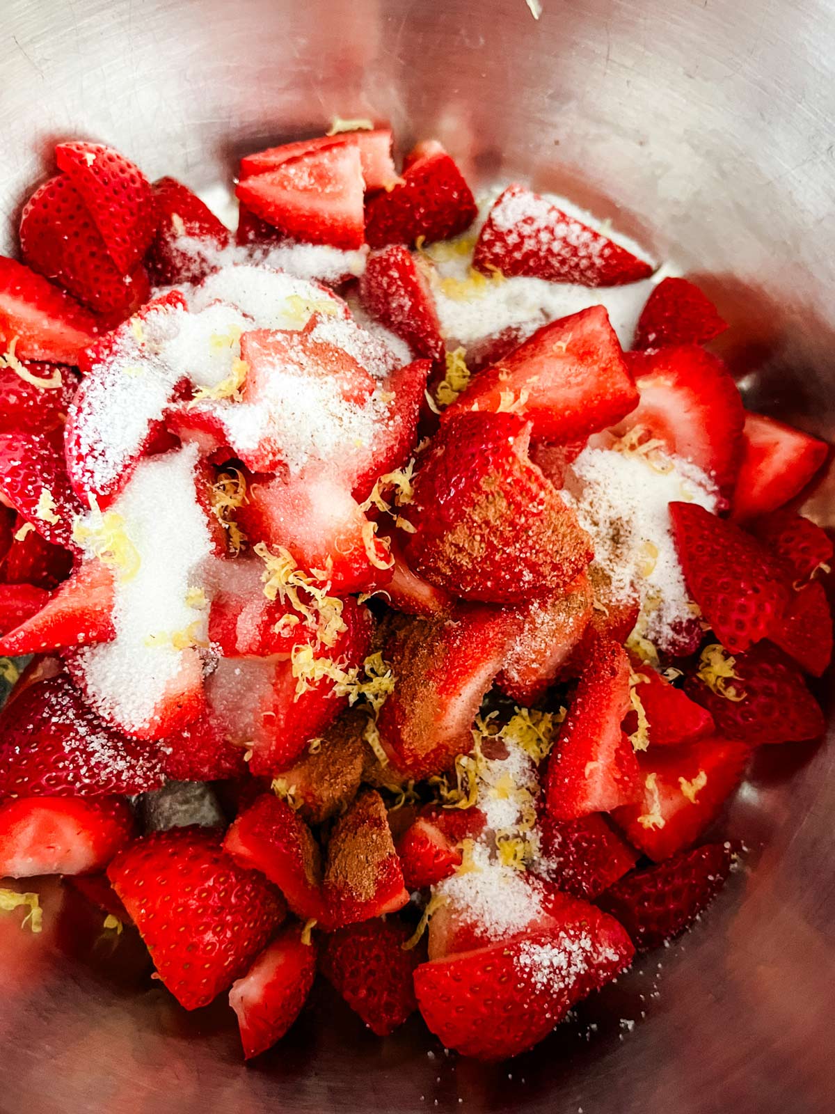 Strawberries, sugar, and lemon zest in a saucepan.