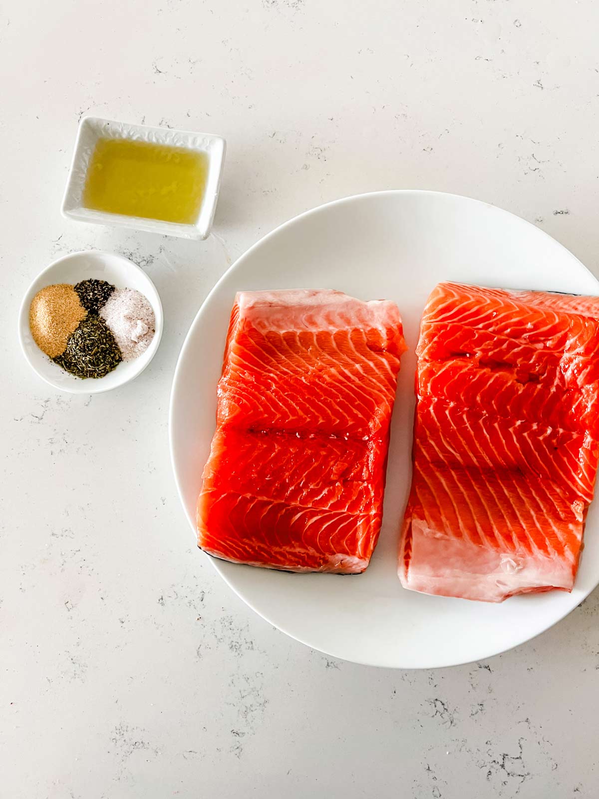 Overhead photo of salmon, seasoning mixture, and oil.