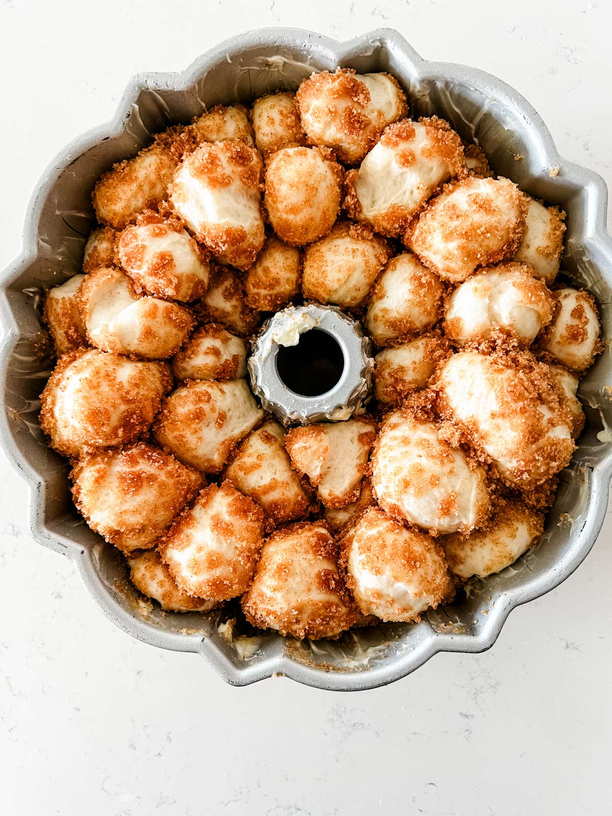 Overhead photo of monkey bread in a bundt pan ready for the oven.