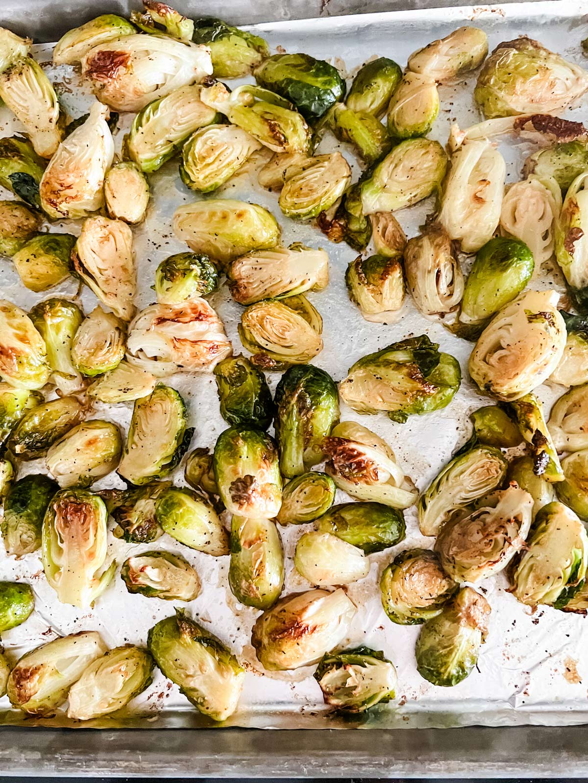 Roasted Brussels sprouts on a foil lined baking sheet.