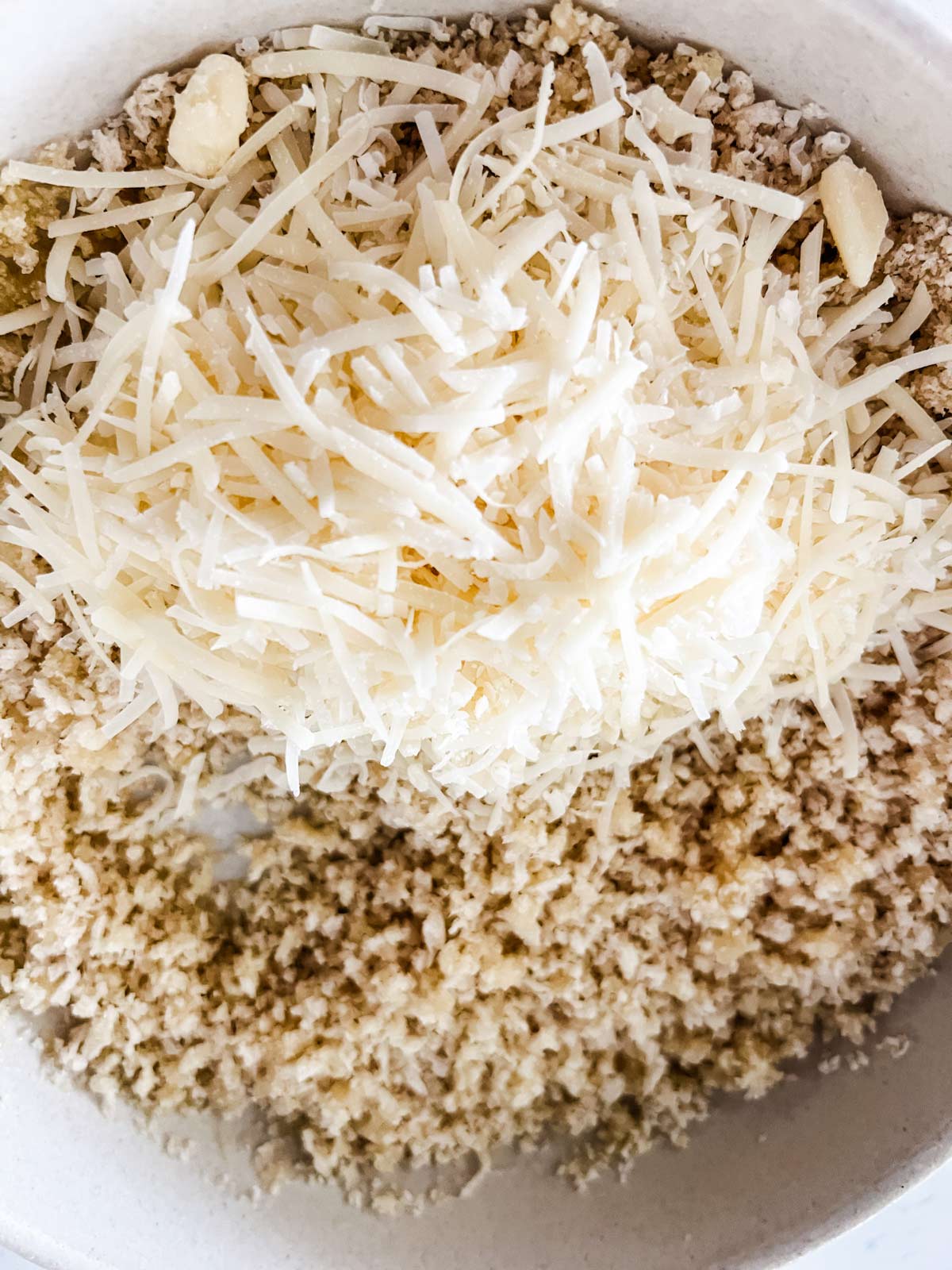Butter coated breadcrumbs and Parmesan cheese in a bowl.