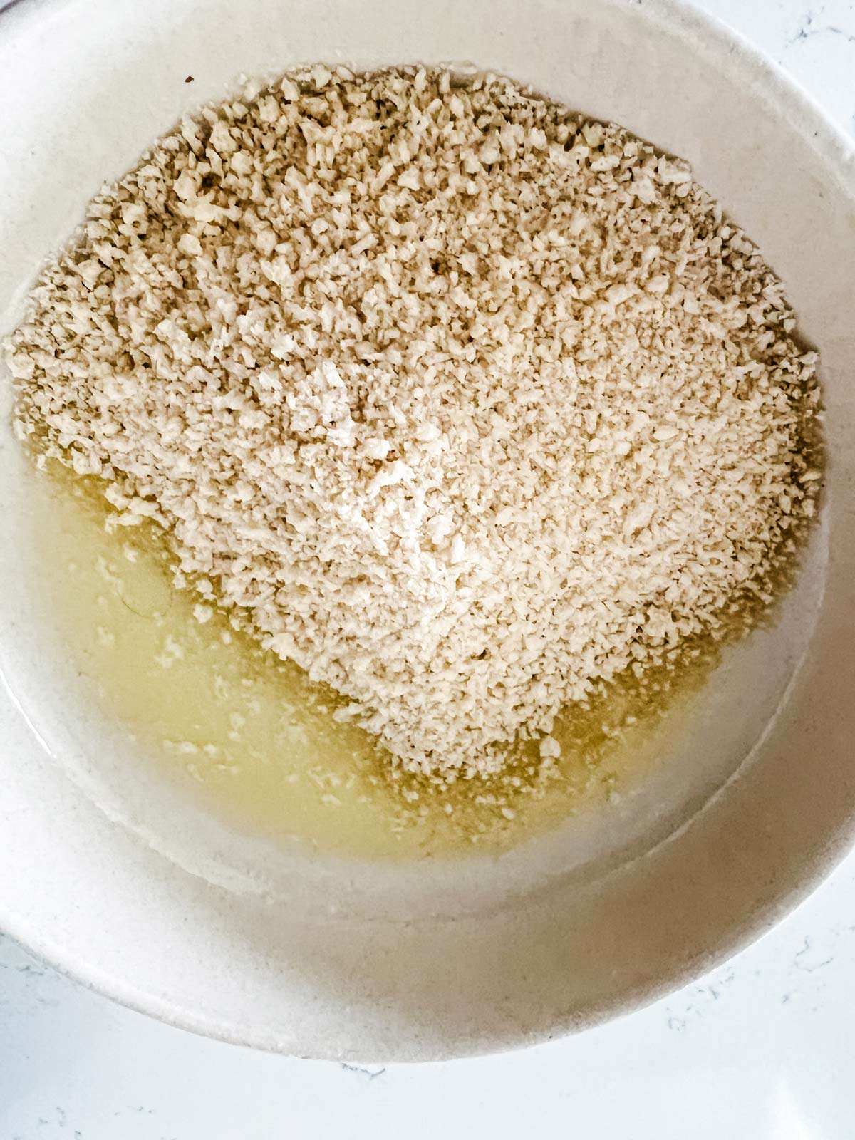 Melted butter and breadcrumbs in a small bowl.