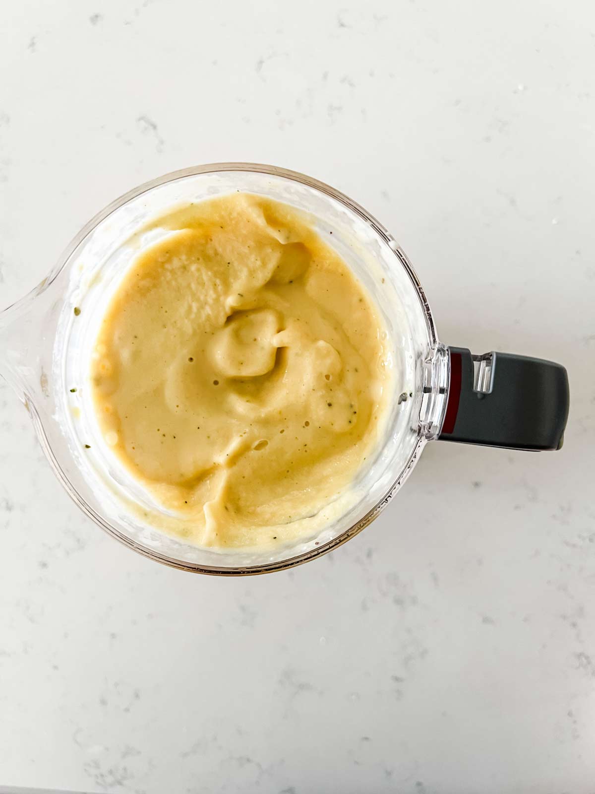 Overhead photo of a pineapple mango smoothie in blender.