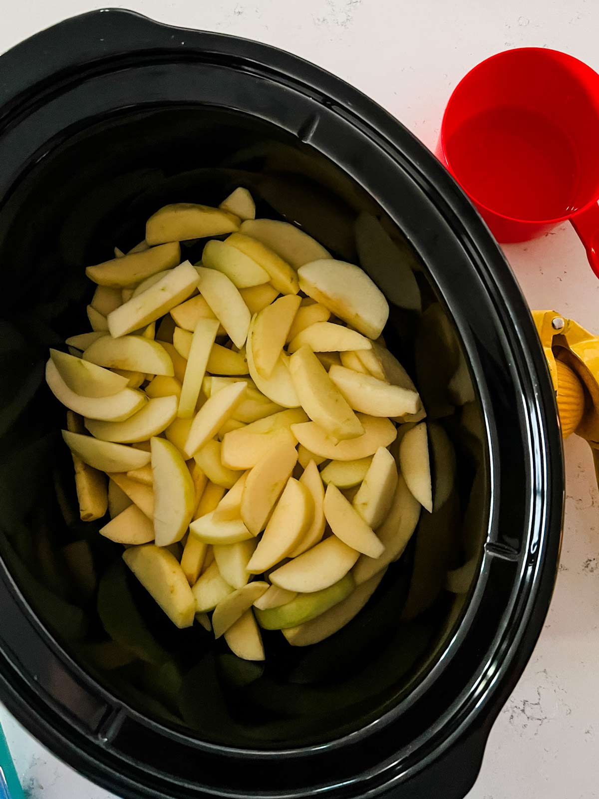 Overhead photo of sliced apples in a slow cooker.