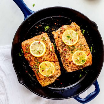 Overhead photo of cooked salmon in a cast iron skillet.