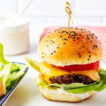 Square side photo of an air fryer burger on a white countertop.