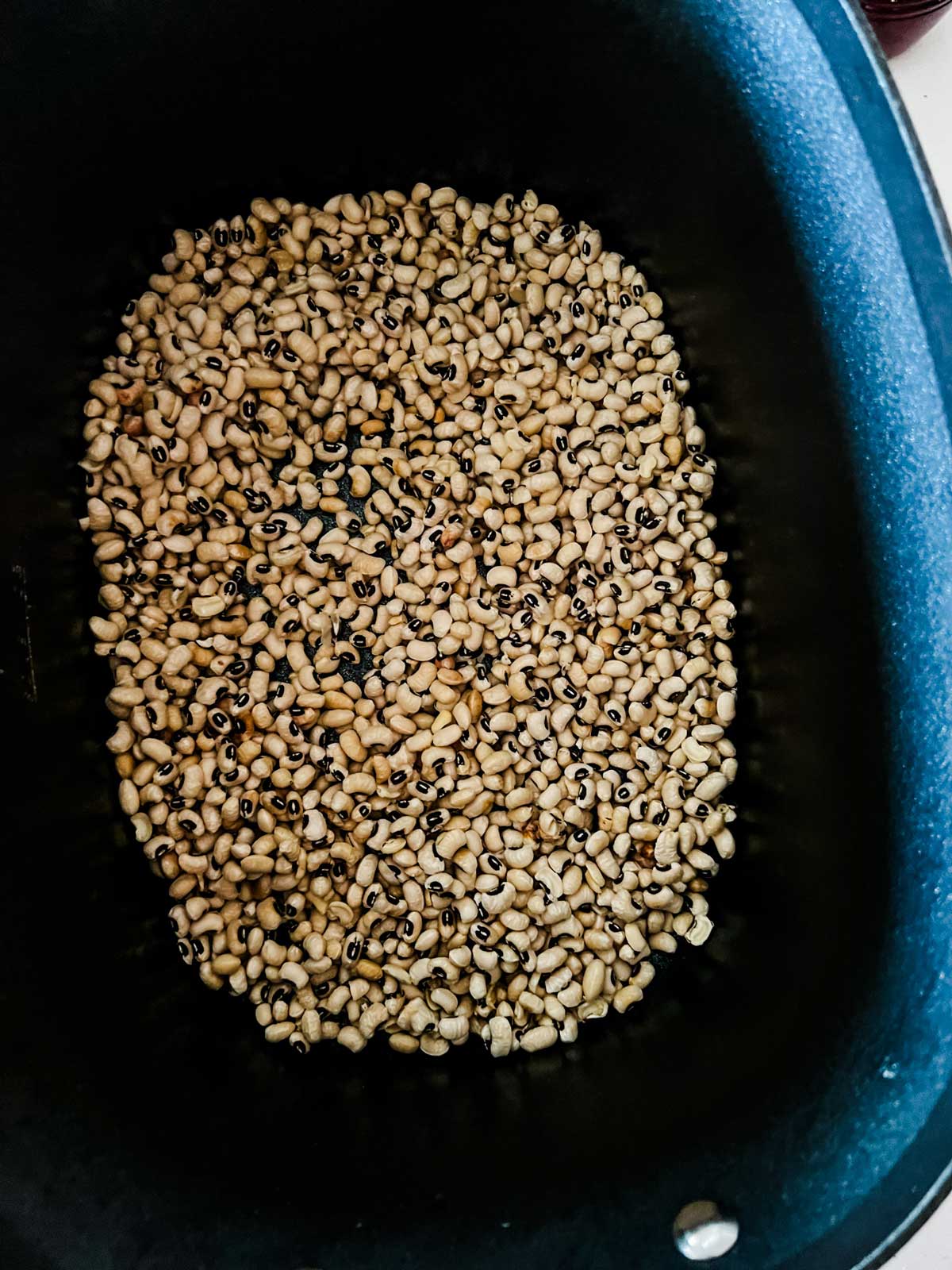 Overhead photo of black eyed peas in a slow cooker.