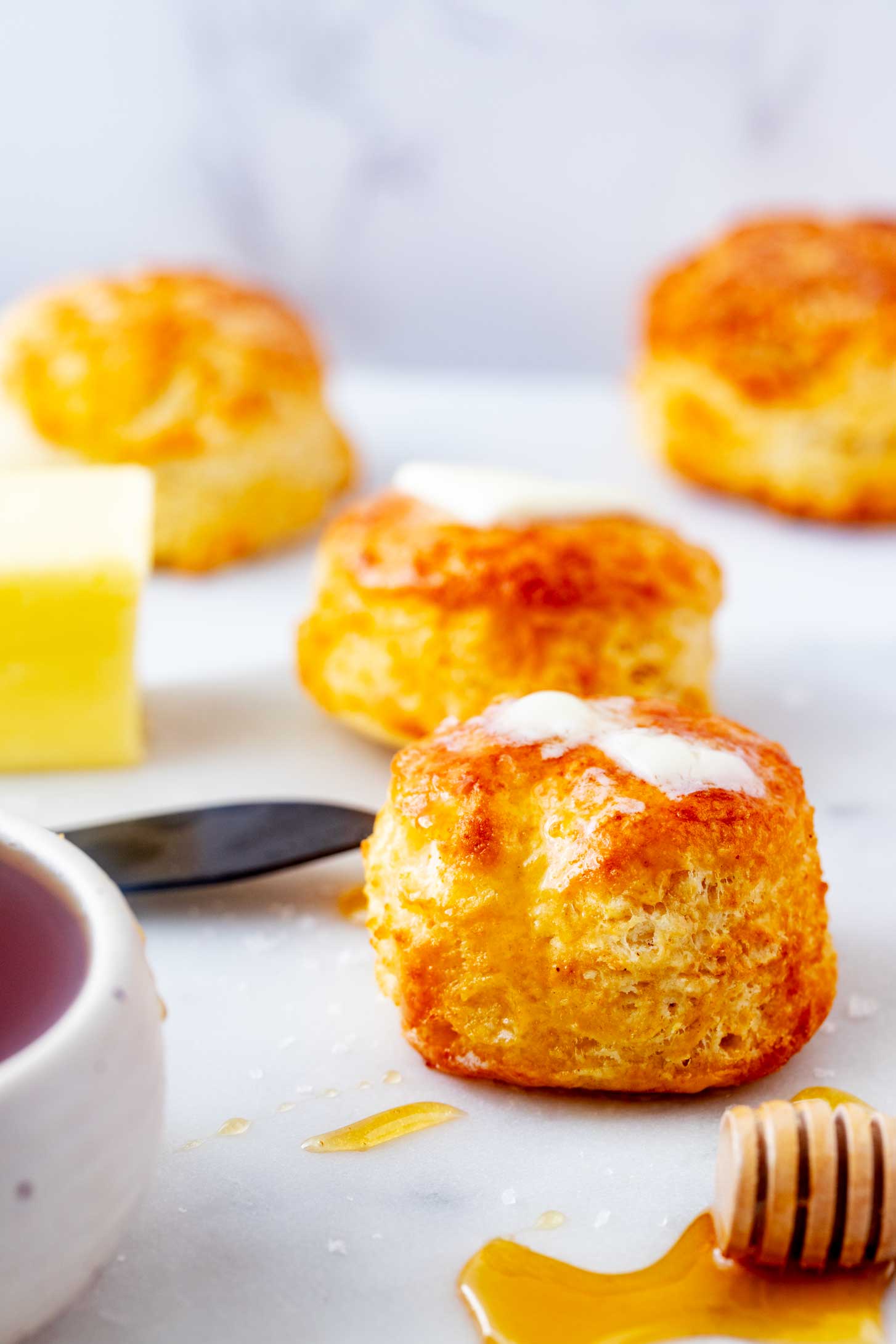 Side photo of air fryer biscuits on a white surface.