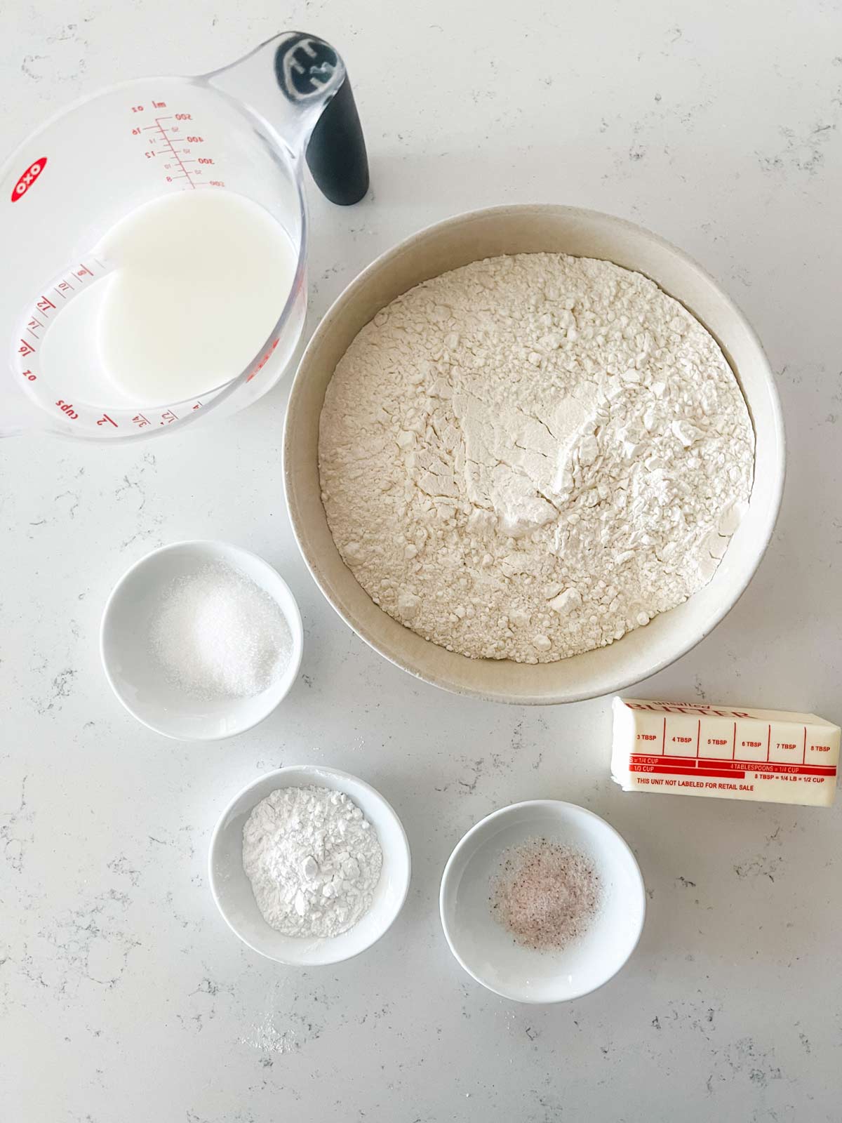 Overhead photo of flour, buttermilk, baking powder, sugar, salt, and butter.