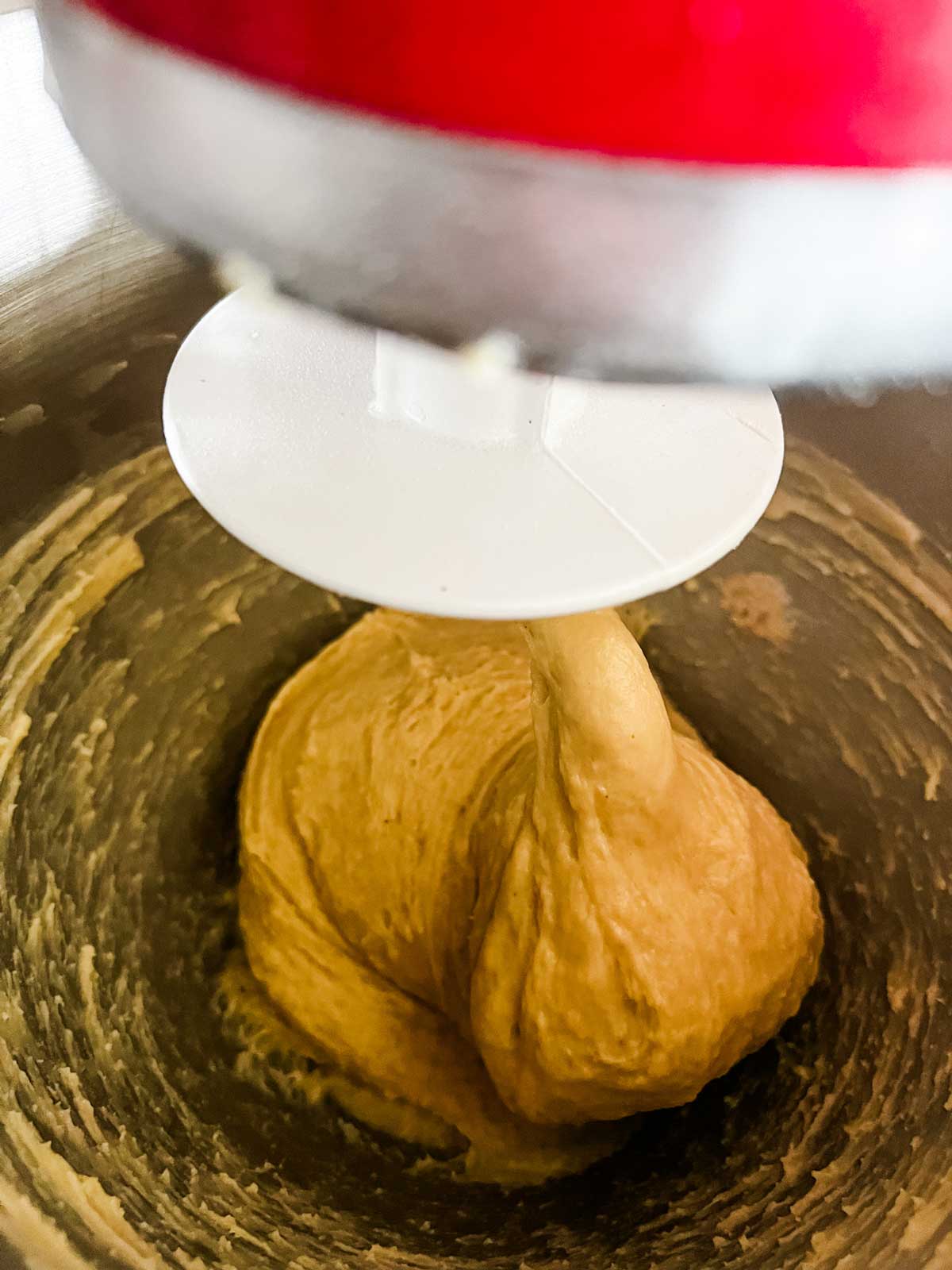 The dough for air fryer cinnamon rolls mixed together in the bowl of a stand mixer.