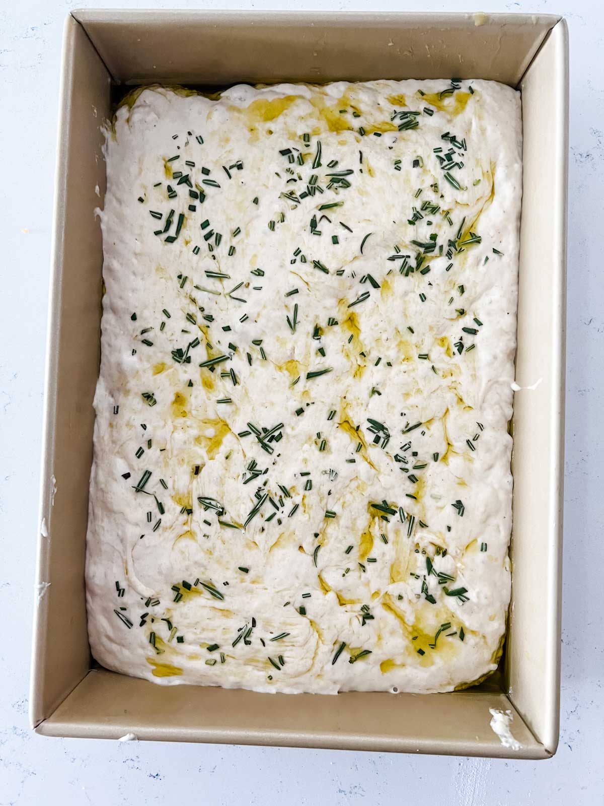 Uncooked focaccia bread that has just rested for 15 minutes.