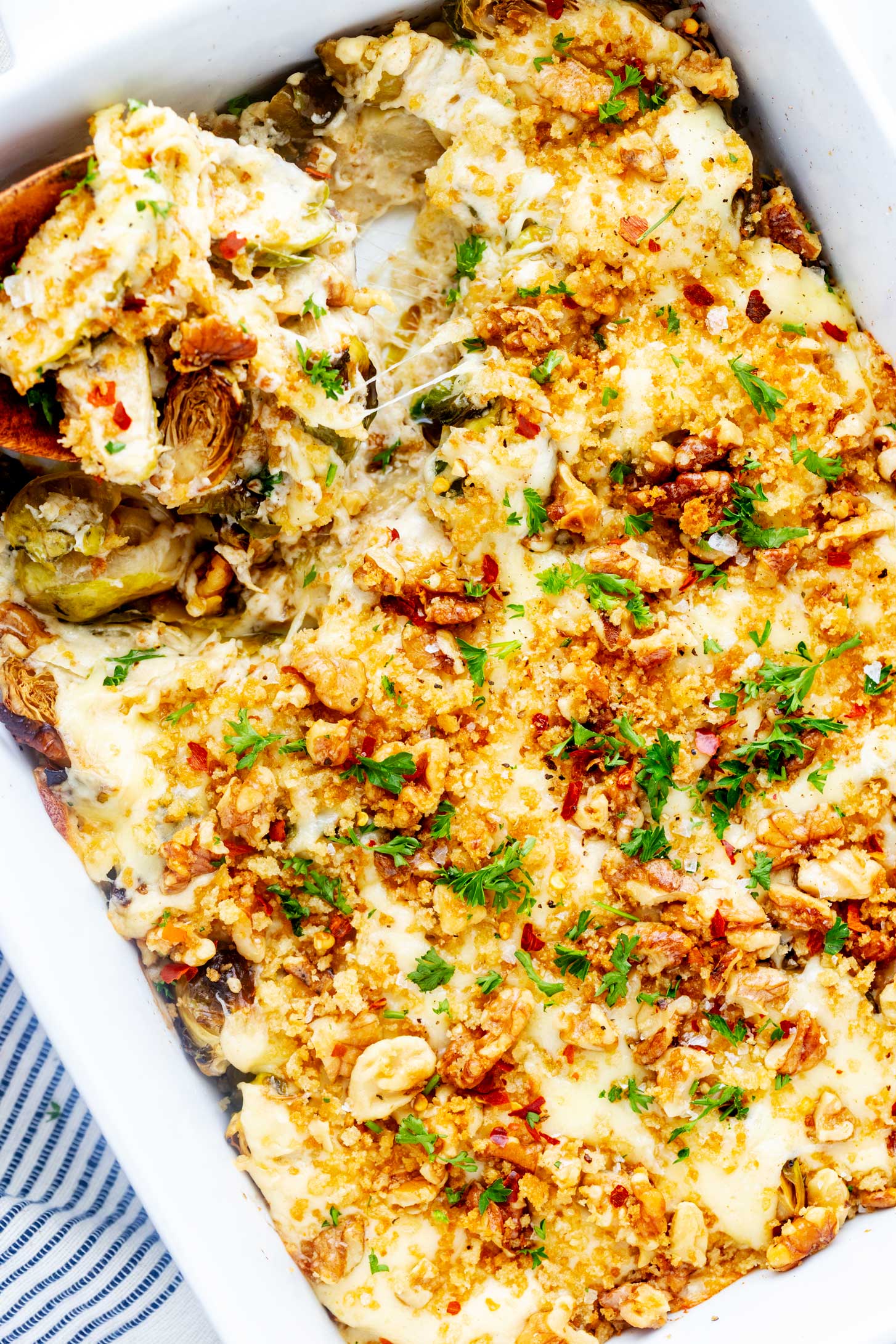 Close up overhead photo of Brussels sprout casserole in a white casserole dash.