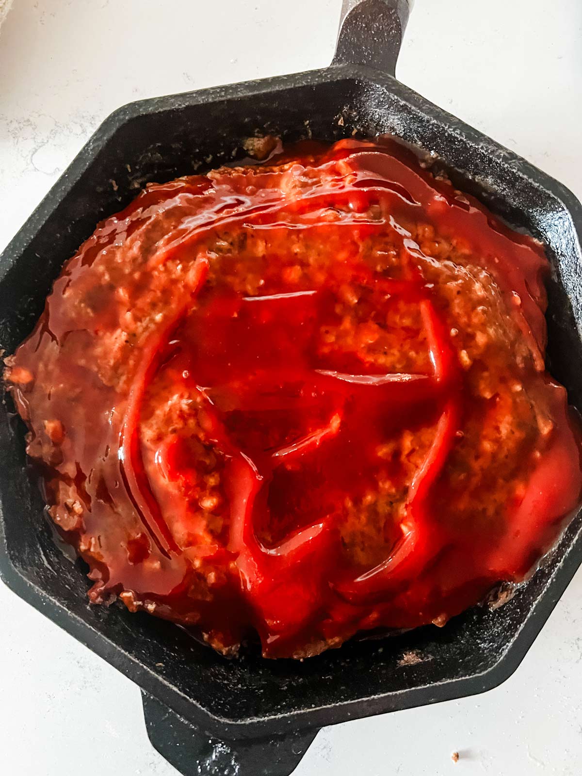 Meatloaf with glaze on it ready to return to the oven.