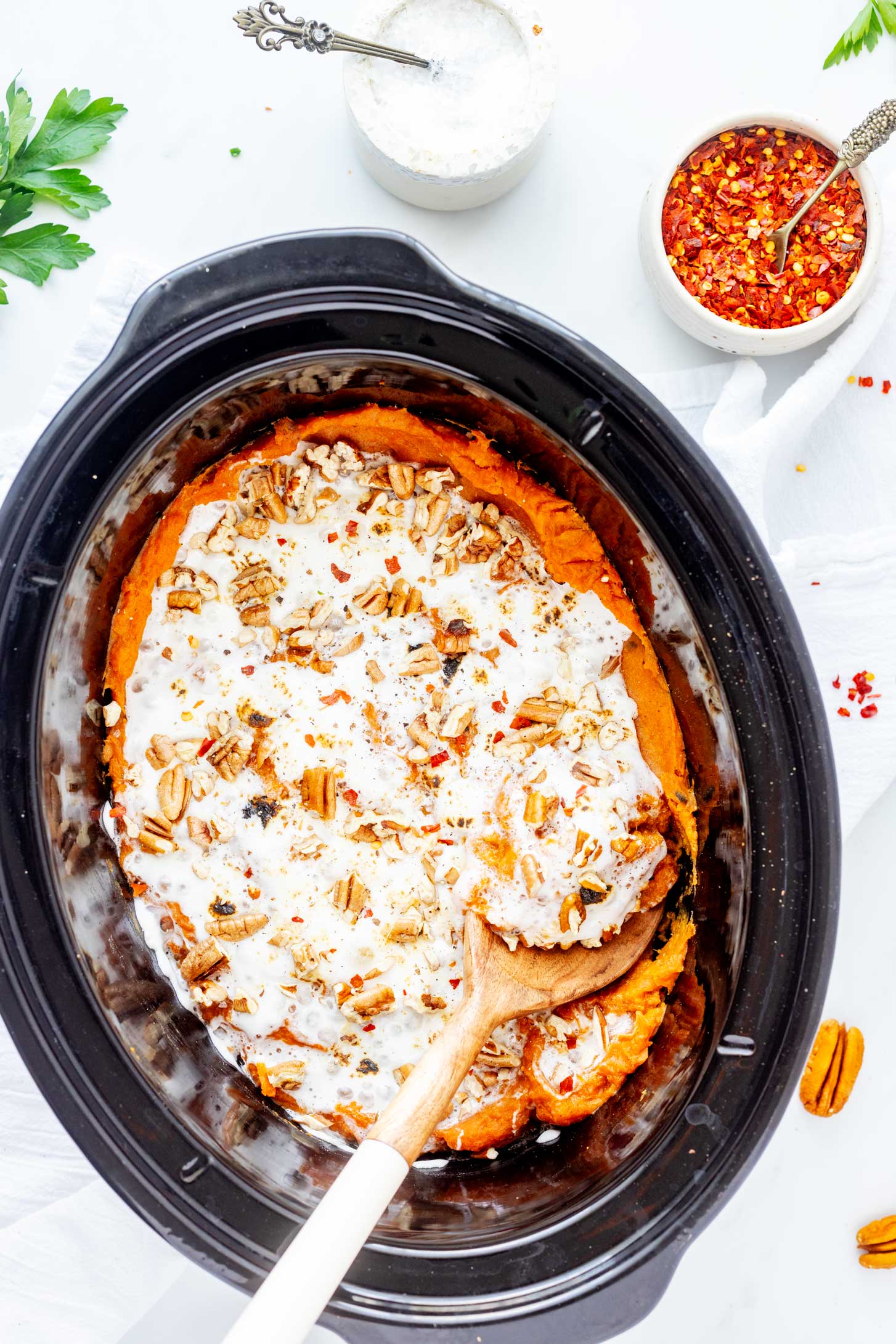 Close up overhead photo of slow cooker sweet potato casserole with a serving spoon in it.