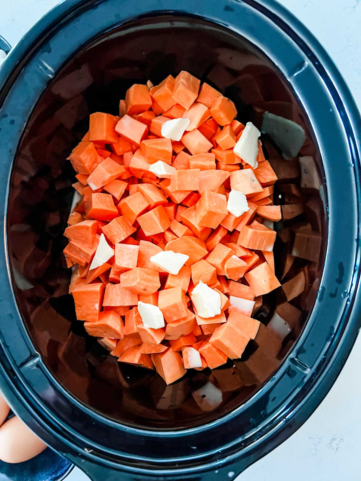 Sweet potatoes and butter in a slow cooker.