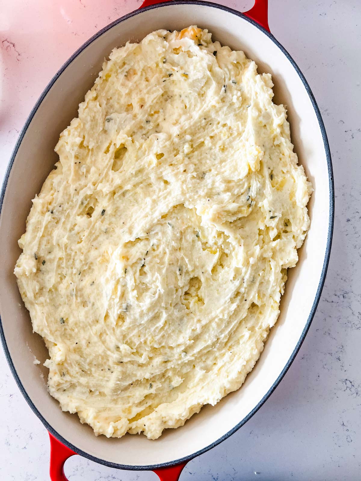 A casserole dish with loaded mashed potatoes in them.