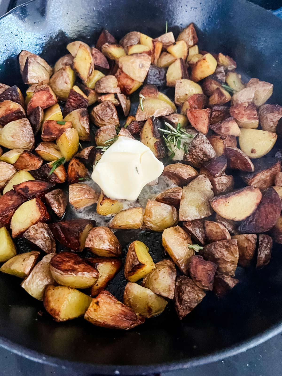 Butter and rosemary added to skillet potatoes.