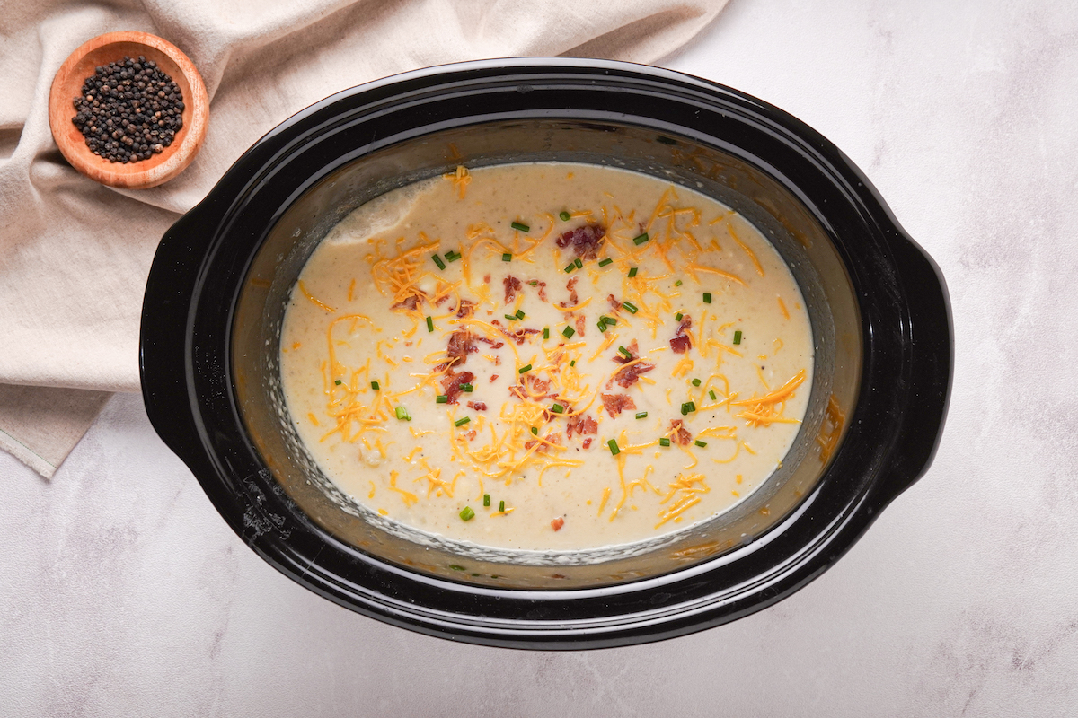 Garnished potato soup in a slow cooker.